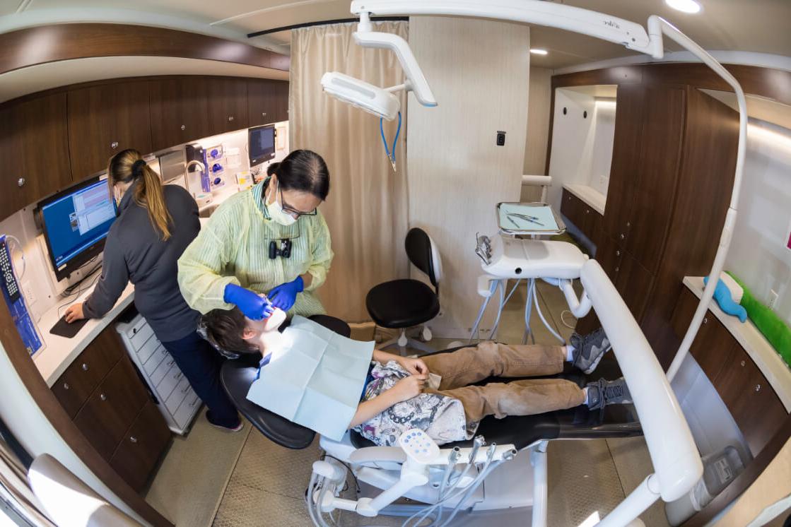 Local student getting dental check-up in SmileMobile as part of URMC community outreach